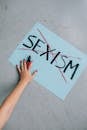 A powerful anti-sexism message on a sign with a red cross, symbolizing empowerment.